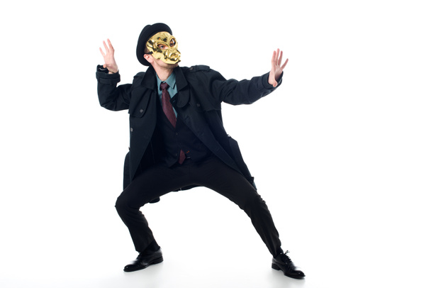 criminal in mask, hat and black coat posing isolated on white - 写真・画像