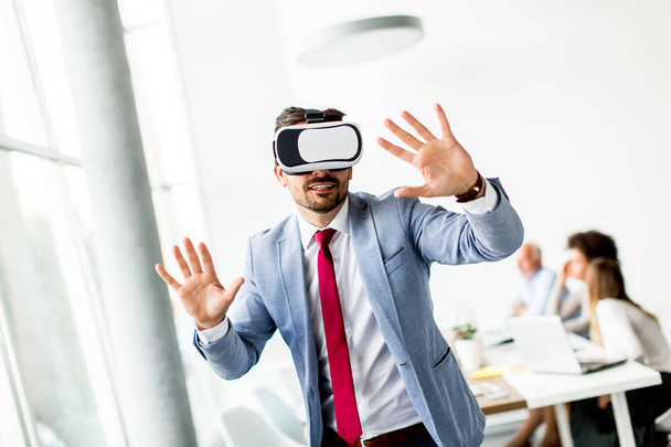 Uomo d'affari moderno con auricolare realtà virtuale in ufficio divertirsi
 - Foto, immagini