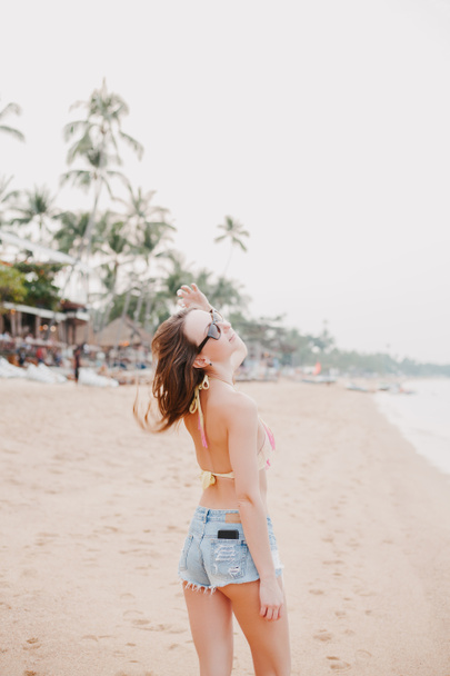 beautiful girl shaking hair on sandy beach  - Zdjęcie, obraz