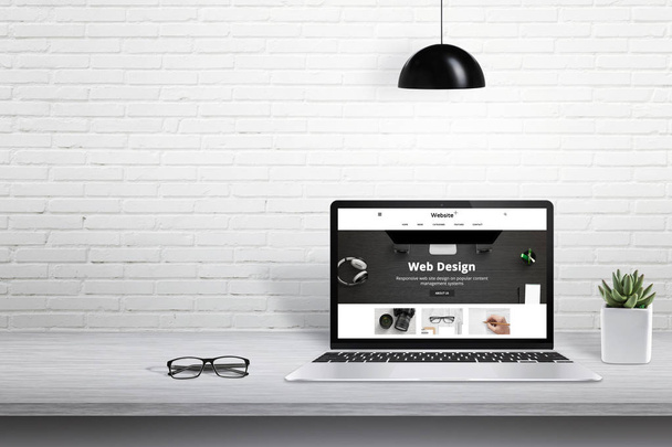 Laptop mit moderner Website-Präsentation. Freiraum für Text neben weißer Ziegelwand. - Foto, Bild