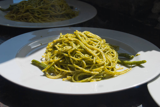 Plate of spaghetti with Ligurian pesto and green beans at the re - Photo, Image