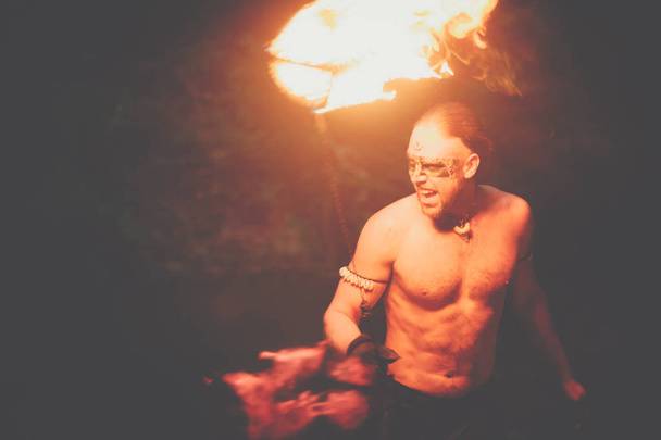 Awesome fire show at the waterfall. Brutal muscle man - Zdjęcie, obraz