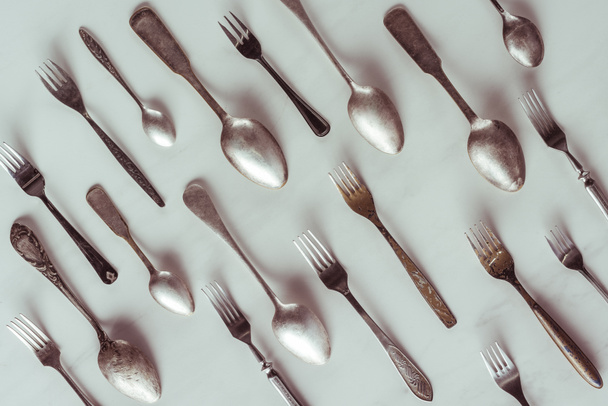 Cuillères et fourchettes vintage sur table blanche
 - Photo, image