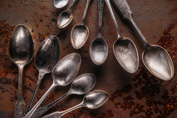 Old metal spoons on rusted background - Foto, afbeelding