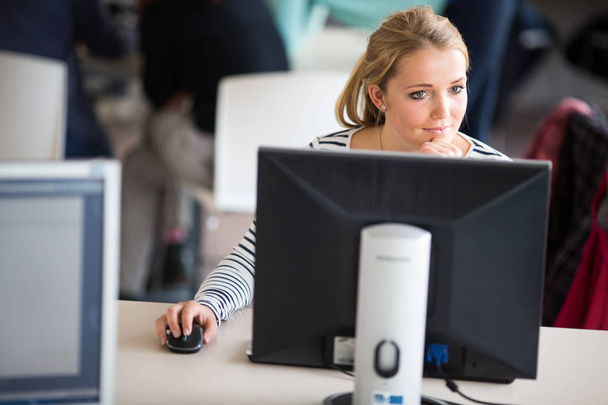 Pretty, female student looking at a desktop computer screen - Foto, Imagem