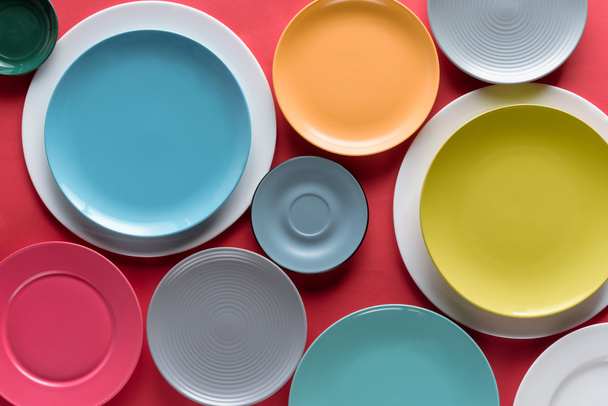 Halom piros háttér színes porcelán tányérok - Fotó, kép