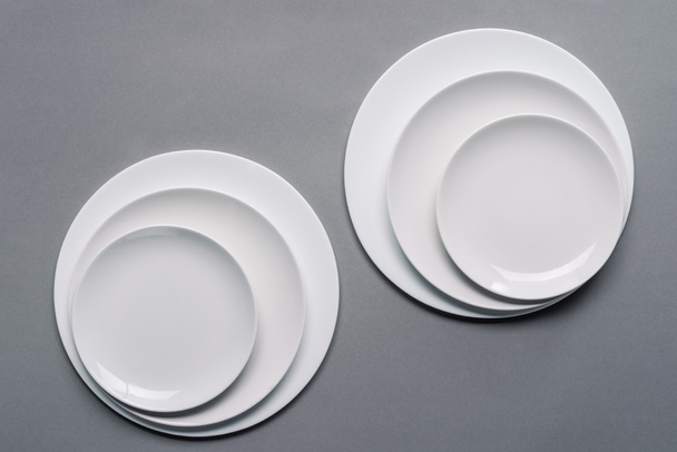 Shiny white kitchen ceramic plates on grey background - Фото, зображення