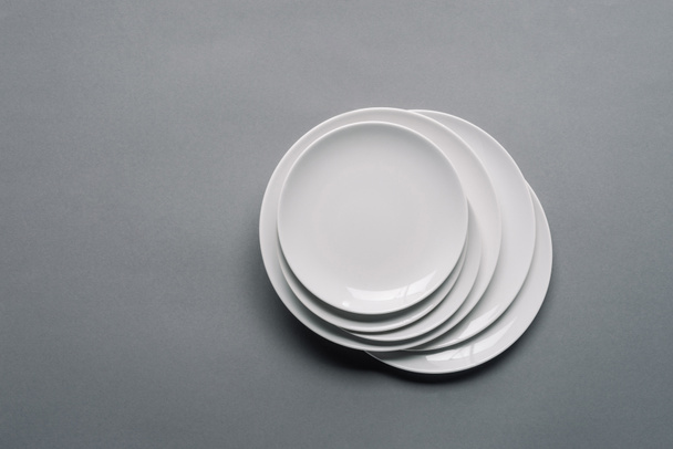 Halom fehér porcelán tányérok a szürke háttér - Fotó, kép
