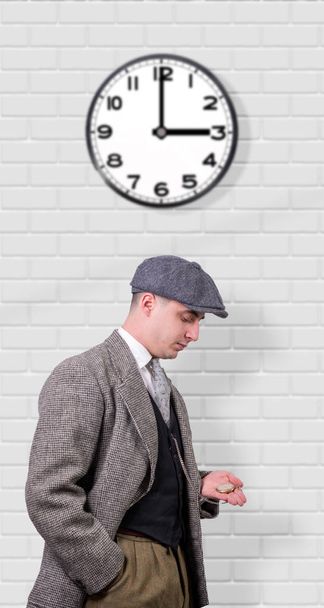 молодий чоловік у старовинному одязі, дивиться годинник, 1940
 - Фото, зображення
