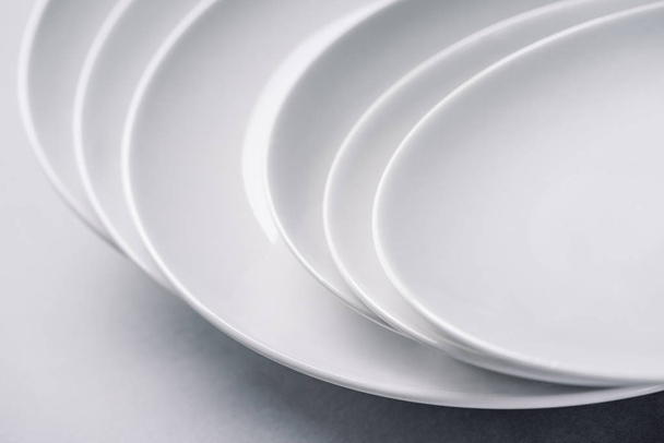 White ceramic plates stacked on white background - Fotografie, Obrázek