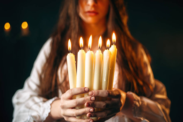 Frau im weißen Hemd mit Kerzen in den Händen, schwarzes magisches Ritual, Okkultismus und Exorzismus, Weissagung - Foto, Bild