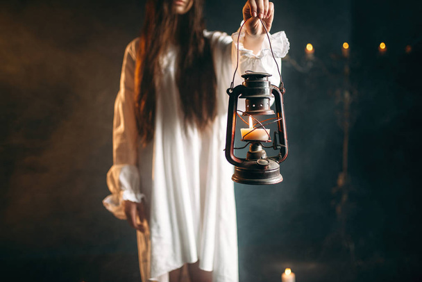 γυναίκα στο λευκό πουκάμισο κρατώντας κηροζίνης, μαύρη μαγεία τελετουργική, απόκρυφη και εξορκισμός - Φωτογραφία, εικόνα
