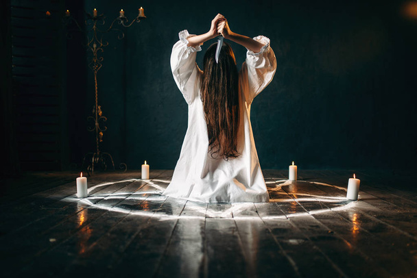mujer con cuchillo sentado en círculo pentagrama con velas, ritual mágico, ocultismo y exorcismo, poder sobrenatural
 - Foto, imagen