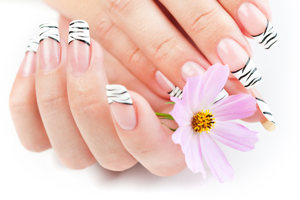 Hands with striped manicure relaxing with flowers - Φωτογραφία, εικόνα