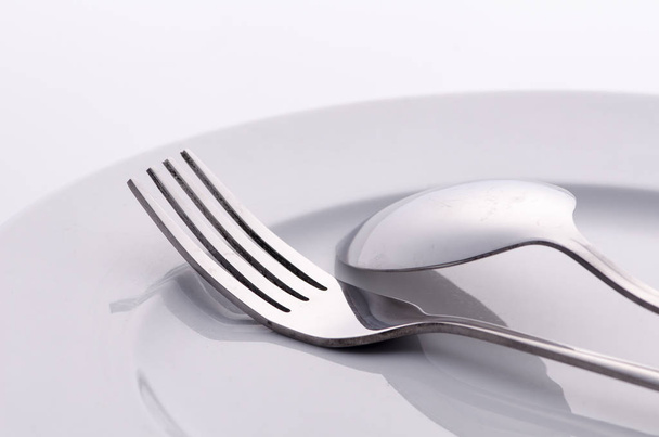fork and silver spoon on white plate - Photo, Image