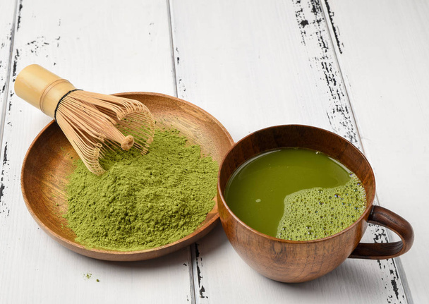 Green tea matcha powder in a wooden bowl with a whisk - Photo, Image