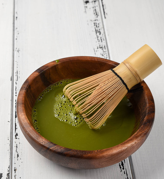 Pó de chá verde matcha em uma tigela de madeira
 - Foto, Imagem