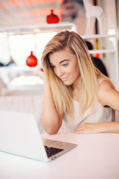 красивая счастливая молодая улыбающаяся деловая женщина работает на ноутбуке в уютном кафе утром
 - Фото, изображение