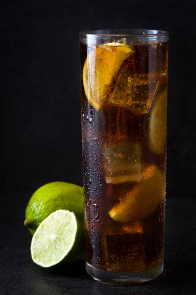 Cuba libre. Cocktail au rhum, citron vert et glace sur fond noir
 - Photo, image
