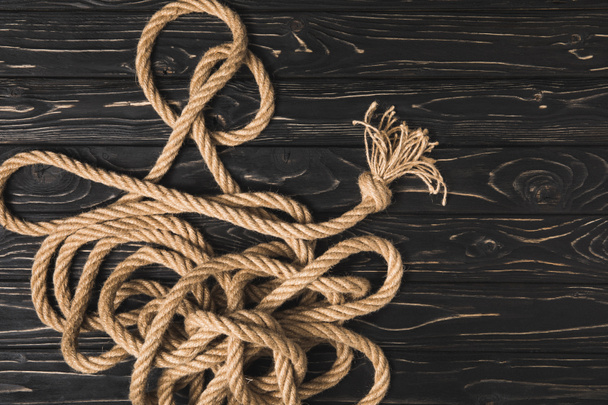 top view of brown nautical rope on dark wooden surface - Photo, Image