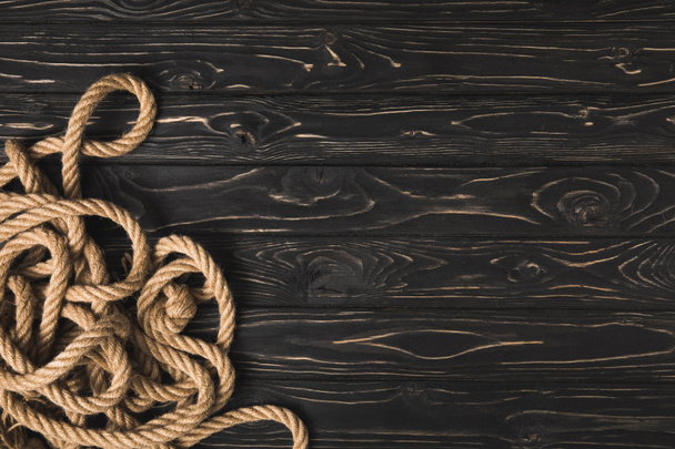 top view of brown nautical rope on dark wooden planks - Фото, зображення