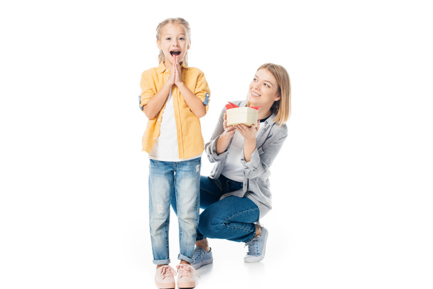 mother with wrapped gift greeting excited daughter isolated on white - Valokuva, kuva