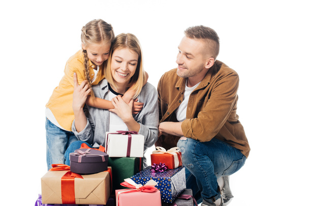 portrait of smiling family and pile of wrapped gifts isolated on white - Foto, imagen