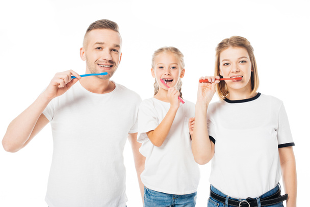 portrait of family in similar clothing brushing teeth isolated on white - Foto, afbeelding