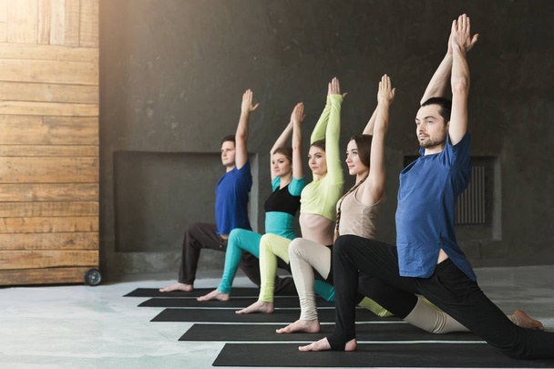 Mujeres jóvenes y hombres en clase de yoga, relajar la meditación pose
 - Foto, Imagen