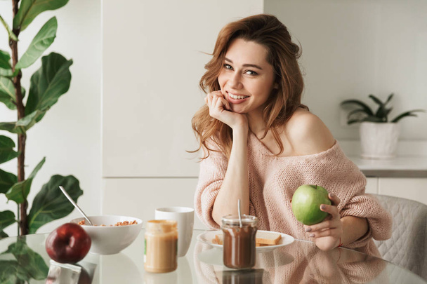 Portrait of a lovely young woman having tasty breakfast - Фото, изображение