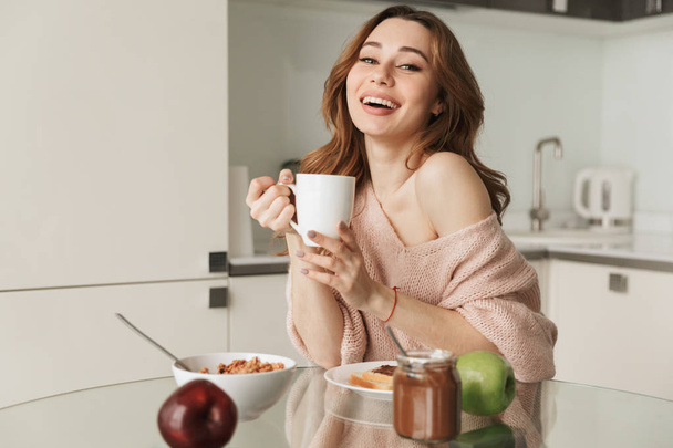 Portrait of a smiling young woman having healthy breakfast - 写真・画像
