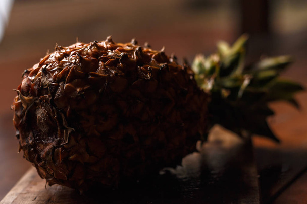 Pineapple on rustic wooden table with blurred background. - Photo, Image