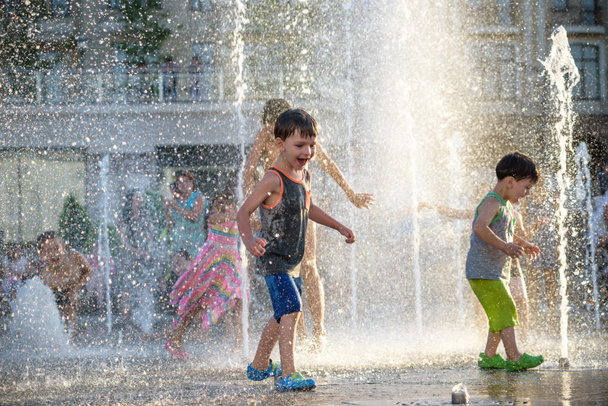 I bambini felici si divertono giocando in fontana d'acqua di città in estate calda
 - Foto, immagini