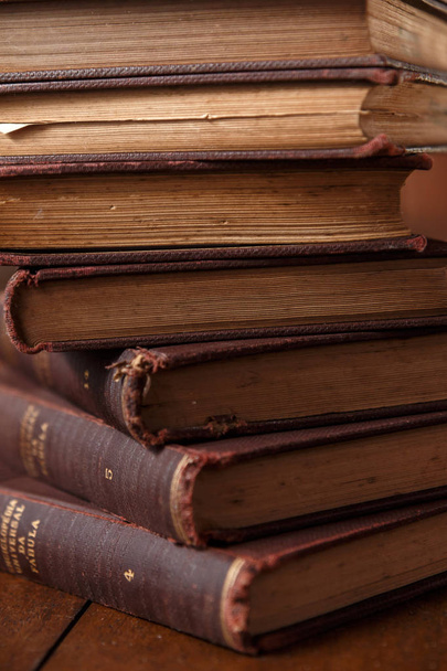 Régi könyvek a rusztikus, fából készült asztal. Verem a könyvek. A háttér életlen. Táj, rusztikus és meleg, barna. - Fotó, kép