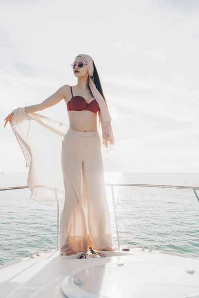 luxurious stylish young woman standing on her white yacht and sailing on the Caribbean sea, vacation - Fotografie, Obrázek