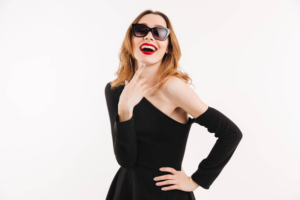 Pleased woman in dress and sunglasses holding arm on hip - Foto, Imagem