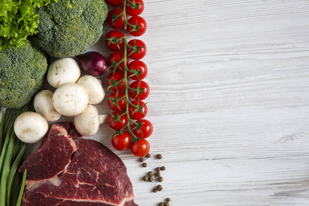 Čerstvé syrové maso hovězí steak s kořením, cherry rajčata, zdravá výživa, pohled shora. Bílé dřevěné pozadí. Kopírovat prostoru. Rozložení bytu - Fotografie, Obrázek