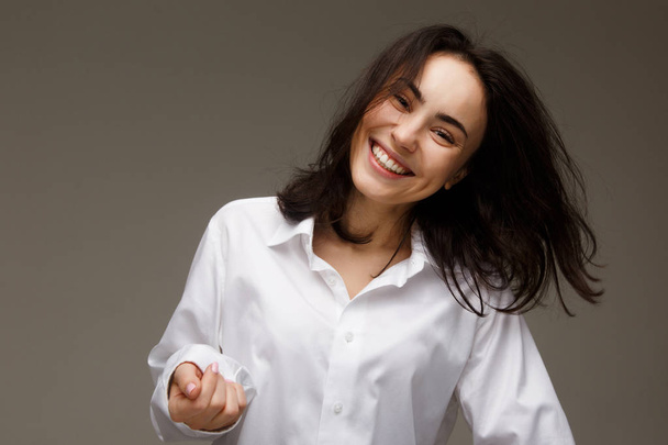 Beautiful girl in a white shirt shows emotions - smile, fun. - Foto, Imagen