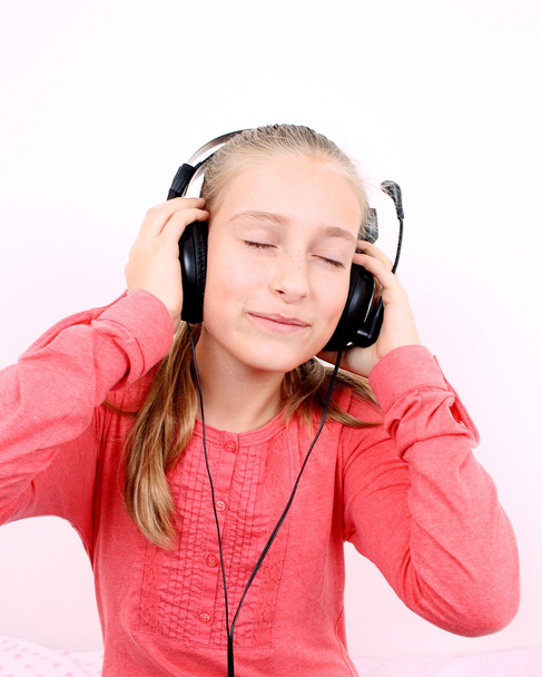 Ragazza bionda felice che ascolta musica con auricolare
 - Foto, immagini