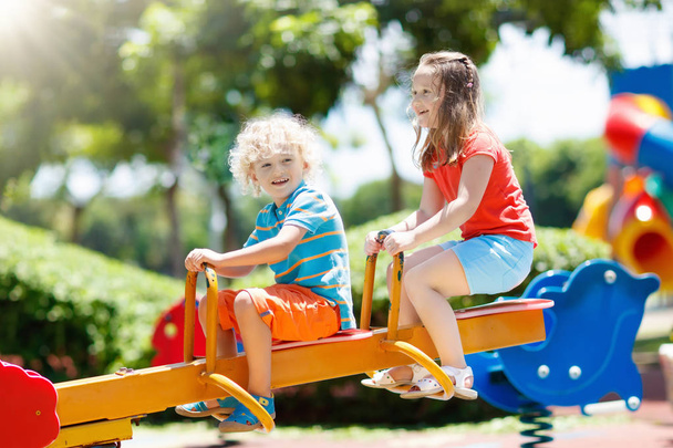 Дети на детской площадке. Дети играют в летнем парке
. - Фото, изображение