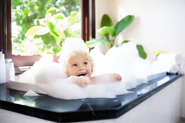 Enfant dans un bain moussant. Un bain de gosse. Bébé sous douche
. - Photo, image