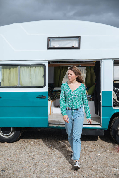 happy young woman in her camper van on the beach - Photo, image