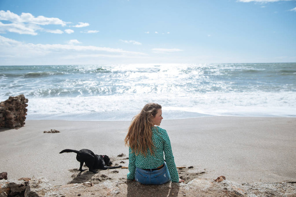 happy woman walking on the beach playing with her dog - 写真・画像