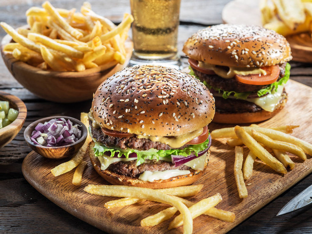 Hamburgers and French fries on the wooden tray. - Photo, Image