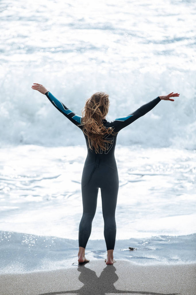 a young woman stretching before swim wearing wetsuit on the seas - Φωτογραφία, εικόνα