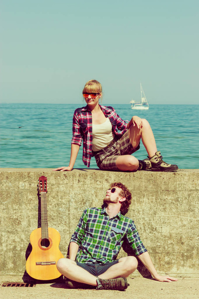 Young man playing guitar to his girlfriend by seaside - Foto, immagini