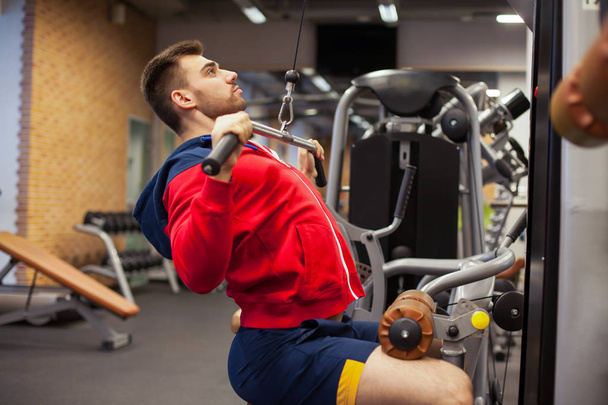 ο άνθρωπος με το βάρος της κατάρτισης στο γυμναστήριο εξοπλισμού sport club - Φωτογραφία, εικόνα