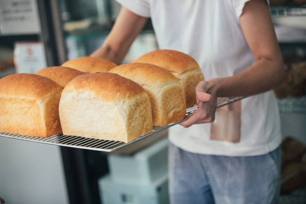 Freshly cooked white bread still in the bread pan - Valokuva, kuva