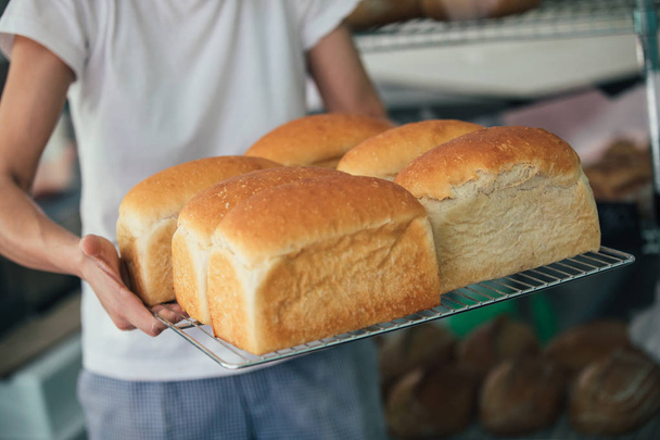 Freshly cooked white bread still in the bread pan - Foto, Imagen