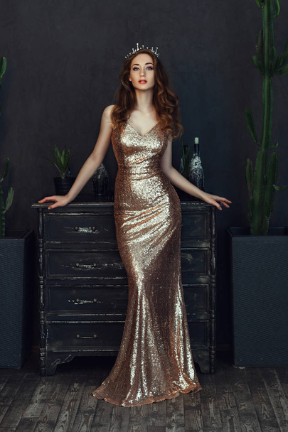 Beautiful model wearing nice dress is posing in a dark studio  - Φωτογραφία, εικόνα